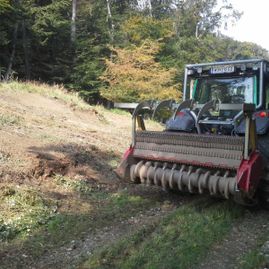 Fahrzeug mit Umgrabemechanik bei der Arbeit auf einem Feldweg