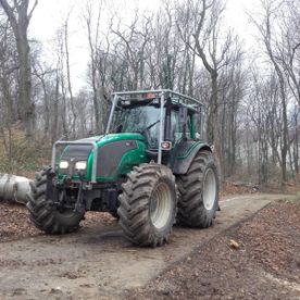 Seitenansicht eines Traktors auf einem Waldweg